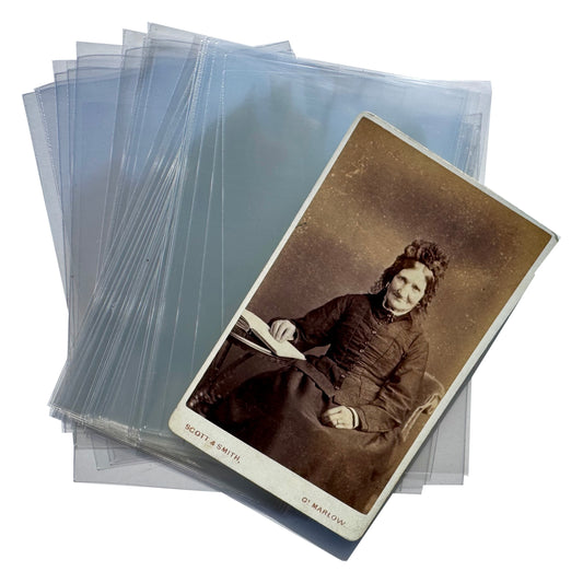 A stack of translucent plastic protective sleeves with one sleeve holding a vintage sepia-toned portrait photograph, photographed on a plain white background.